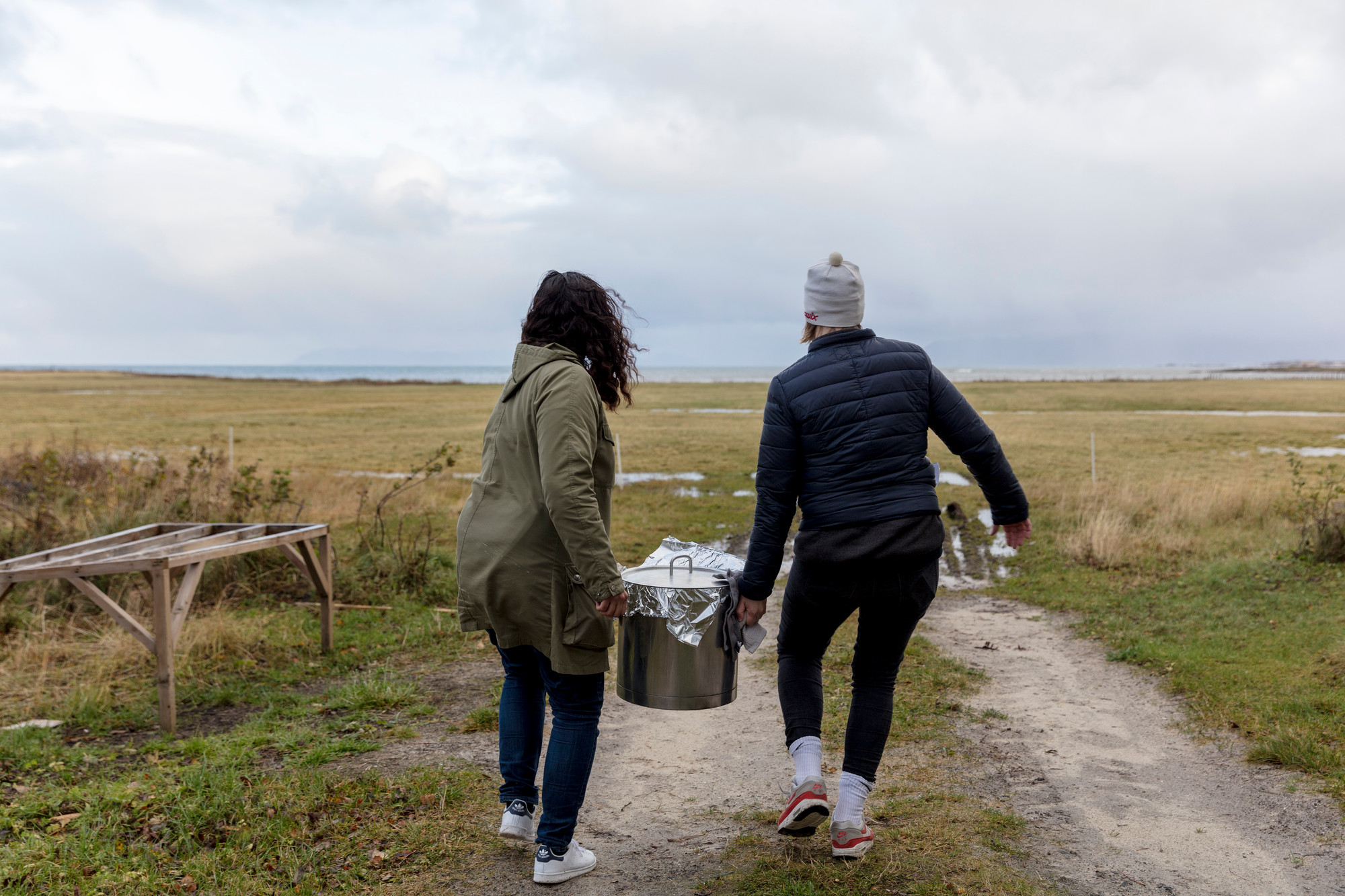 Maya Økland and Pernille Mercury Linstad bringing lunch in Lofoten, during Rugged, weathered, above the sea, curated by Charles Aubin (FR/US), 2018. Photo: Christian Tunge.